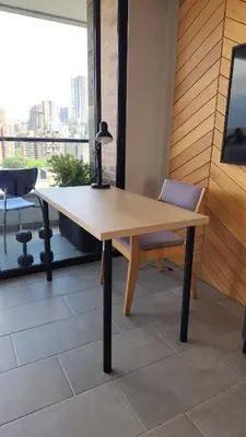 a wooden table and a chair in a room with a window at The best location in Poblado Air conditioning in Medellín