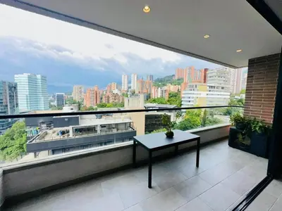 a balcony with a table and a view of a city at The best location in Poblado Air conditioning in Medellín