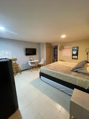a bedroom with a bed and a table and chairs at Apartaestudio 304 in Medellín