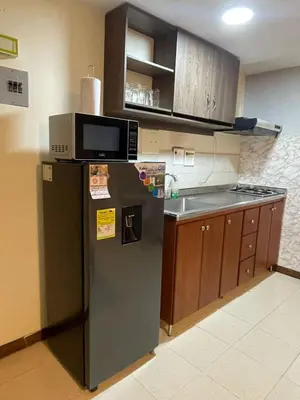 a kitchen with a refrigerator and a microwave at Apartaestudio 304 in Medellín