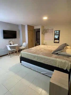 a bedroom with a large bed and a table at Apartaestudio 304 in Medellín