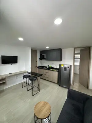 a living room with a table and chairs and a kitchen at céntrico y acogedor apartamento in Sabaneta