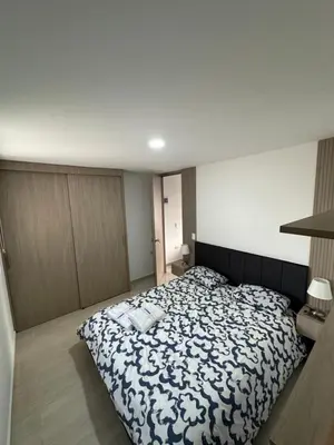 a bedroom with a bed with a black and white blanket at céntrico y acogedor apartamento in Sabaneta