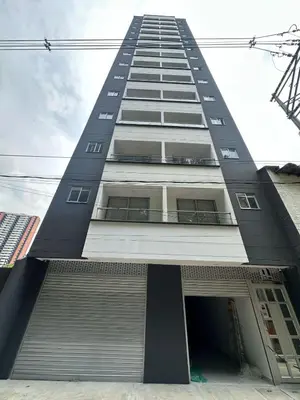 a tall apartment building with a garage at céntrico y acogedor apartamento in Sabaneta