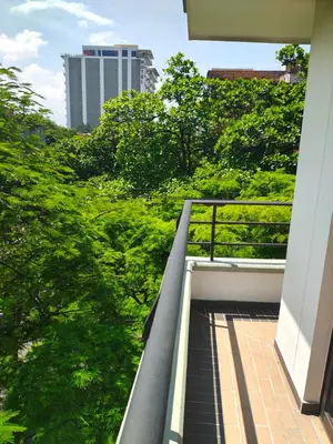a balcony with a view of trees and a building at Apto 2 zona rosa sector la 70 estadio in Medellín