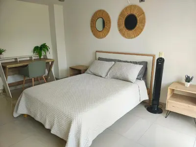 a bedroom with a bed and a desk and a mirror at Apto 2 zona rosa sector la 70 estadio in Medellín
