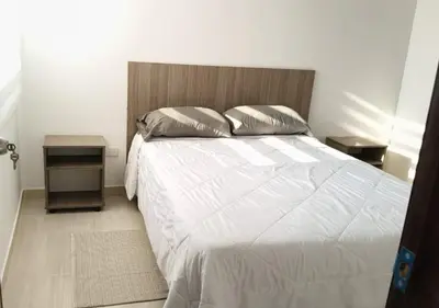 a bedroom with a large white bed with two pillows at Apartamentos Nuevos 2 y 3 habitaciones 6 personas - Cerca a Expoferias y Bosque Popular, Cable Aereo in Manizales