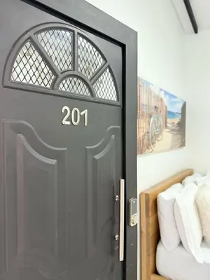 a gray door with a number on it next to a bed at Casa Bendita 201 Espectacular in Medellín