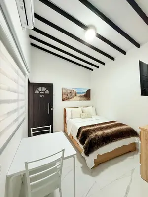 a bedroom with a bed and a table and a tv at Casa Bendita 201 Espectacular in Medellín