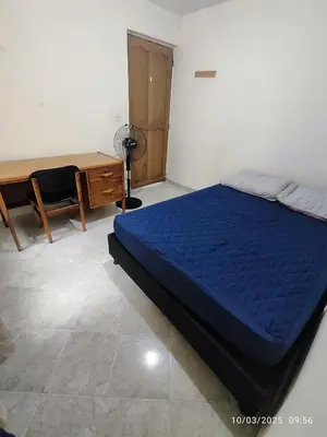 a bedroom with a blue bed and a desk and a desk at Comoda Casa en Itagüí, cerca de Medellín! Ideal para Familias y Grupos in Itagüí