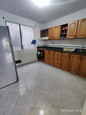 a kitchen with wooden cabinets and a white refrigerator at Comoda Casa en Itagüí, cerca de Medellín! Ideal para Familias y Grupos in Itagüí