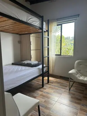 a bedroom with two bunk beds and a chair at Casa Campestre in Santa Bárbara