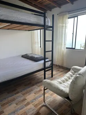 a bedroom with a bunk bed and a chair at Casa Campestre in Santa Bárbara