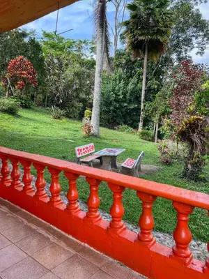 a red fence with a table and benches in a park at FINCA ARCANOS CELESTe in Barbosa