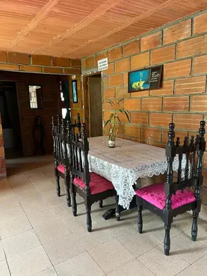 a table and chairs in a room with a brick wall at FINCA ARCANOS CELESTe in Barbosa