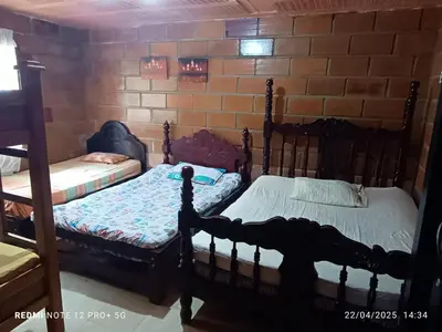 two beds in a room with a brick wall at FINCA ARCANOS CELESTe in Barbosa