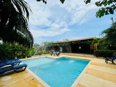 a large swimming pool with blue chairs in a yard at Finca Campestre El Patujo in Doradal