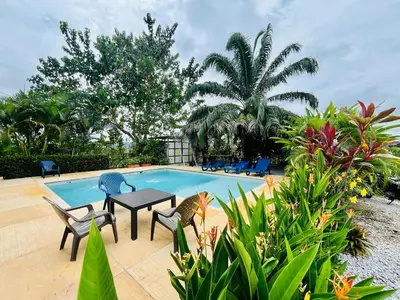 a swimming pool with chairs and a table next to it at Finca Campestre El Patujo in Doradal