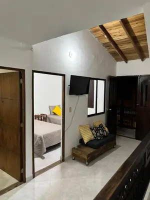 a bedroom with a bed and a couch and a mirror at Pedacito de cielo in Jardin