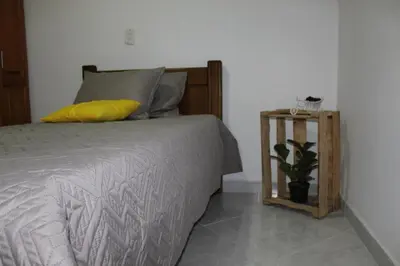 a bedroom with a bed with a yellow pillow and a table at Pedacito de cielo in Jardin