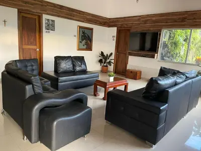 a living room with black leather furniture and a flat screen tv at Finca La Mediterránea en San Jerónimo in San Jerónimo