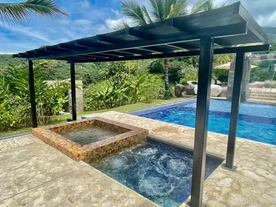 a pergola over a swimming pool in a backyard at Finca La Mediterránea en San Jerónimo in San Jerónimo