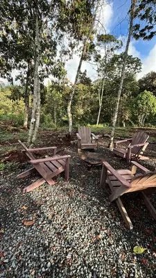 a group of picnic tables and chairs in the woods at Tiny House Minimalista en la Naturaleza cerca a El Retiro y La Ceja in El Retiro