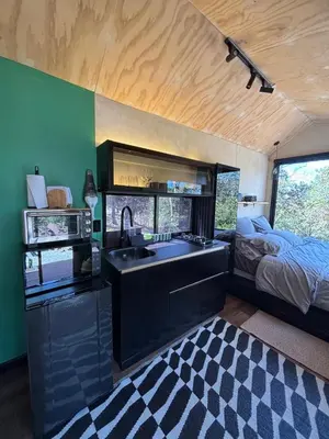 a kitchen with a sink and a bed in a room at Tiny House Minimalista en la Naturaleza cerca a El Retiro y La Ceja in El Retiro