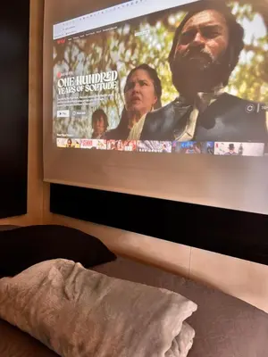 a large screen with a movie projected on a wall at Tiny House Minimalista en la Naturaleza cerca a El Retiro y La Ceja in El Retiro