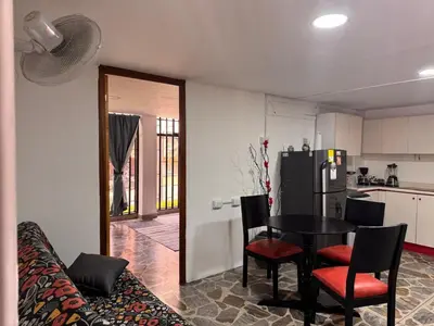 a room with a table and chairs and a kitchen at Nice place to stay in Medellín