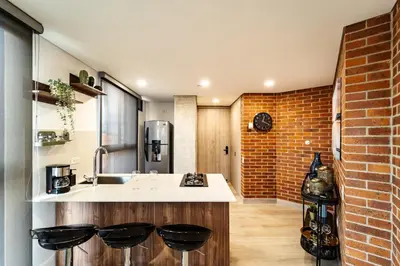 a kitchen with a sink and a brick wall at Apartamentos Medellín Caribe Suite in Medellín