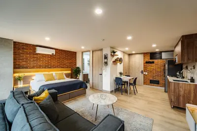 a bedroom and a living room with a bed and a kitchen at Apartamentos Medellín Caribe Suite in Medellín