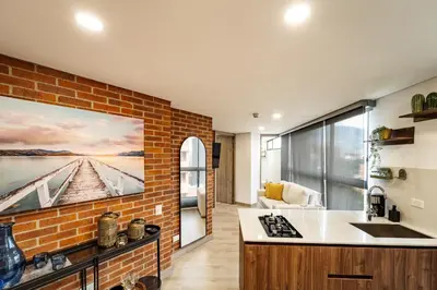a kitchen with a large painting on the wall at Apartamentos Medellín Caribe Suite in Medellín