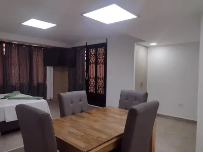 a dining room with a wooden table and chairs at Apartamento La Paz in Envigado
