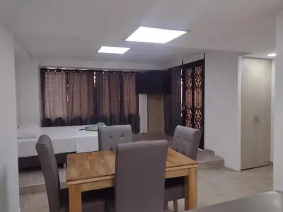 a dining room with a table and chairs and a bed at Apartamento La Paz in Envigado