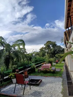 a patio with chairs and tables and trees at Oru Forest Retreat & Eco Lodge, just 15 minutes from the airport in Envigado