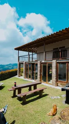 a dog laying on the grass in front of a house at Oru Forest Retreat & Eco Lodge, just 15 minutes from the airport in Envigado