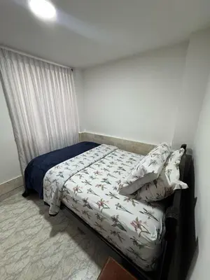 a small bedroom with a bed with a bedspread and pillows at Apartamento Edificio Parques Del Trianon in Envigado