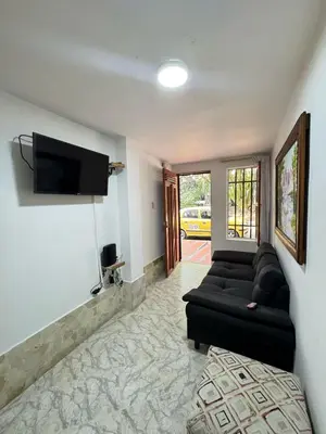 a living room with a black couch and a flat screen tv at Apartamento Edificio Parques Del Trianon in Envigado