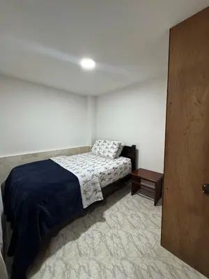 a small bedroom with a bed and a table at Apartamento Edificio Parques Del Trianon in Envigado
