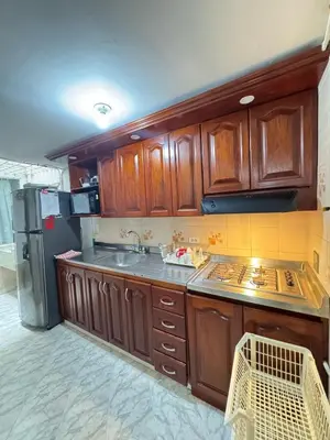 a kitchen with wooden cabinets and a stainless steel refrigerator at Apartamento Edificio Parques Del Trianon in Envigado