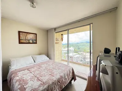 a bedroom with a bed and a sliding glass door at Cantabria in Manizales