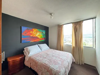 a bedroom with a bed and a large window at Cantabria in Manizales