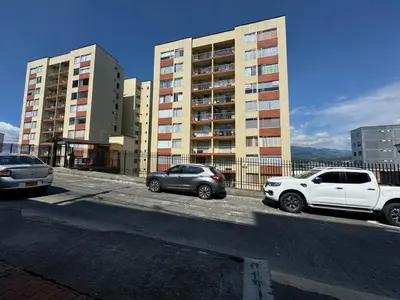 two cars parked in a parking lot in front of buildings at Cantabria in Manizales