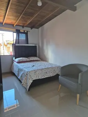 a bedroom with a bed and a chair at Apartamento Super Lindo in Medellín