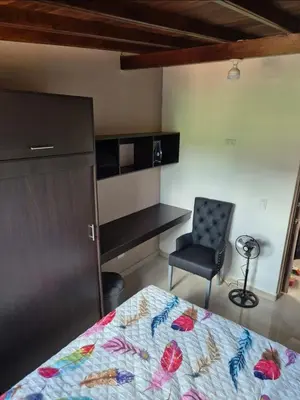 a bedroom with a bed and a chair and a desk at Apartamento Super Lindo in Medellín