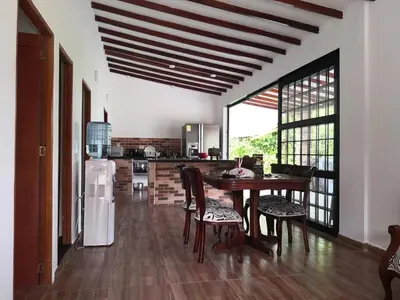 a kitchen with a table and chairs and a refrigerator at Finca Villa Andrea 1h20min desde Medellín Niquía in Santa Rosa de Osos