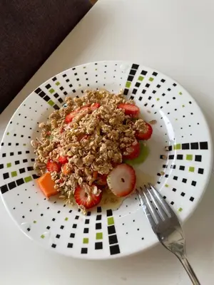 a plate of food with strawberries and granola and a fork at Glamping Resort Jonico Finca in Chinchiná