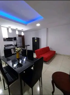 a living room with a table and a red couch at excelente ubicación Milán in Manizales