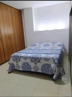 a bedroom with a bed with a blue and white blanket at excelente ubicación Milán in Manizales